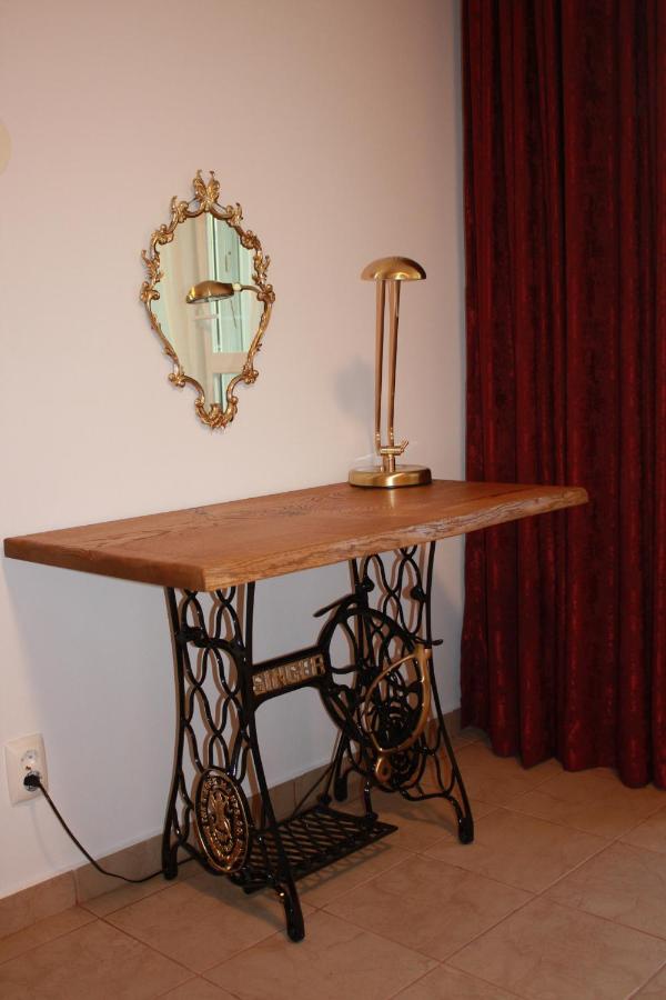 The bedroom table on the cast-iron base of a sewing machine, with a gilded mirror